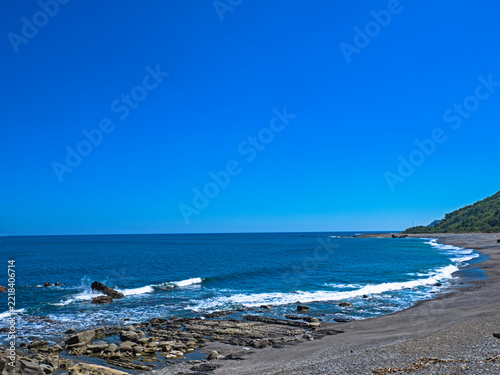 Sunny coastline with blue sea and green hills in Xuhai, Pingtung, Taiwan.  
