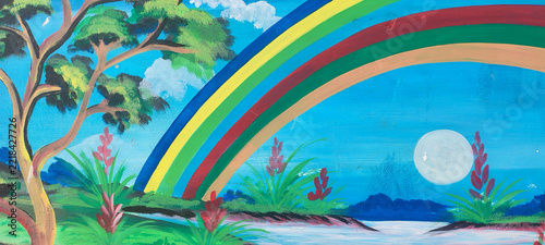 Bright rainbow arching over lush green forest landscape