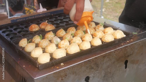 the process of cooking takoyaki using traditional molds, the most popular and delicious Japanese street food.