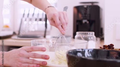 Pastry preparation. Mixing process. Female chef hand whisking butter sugar ingredients for homemade dough in glass bowl countertop.
