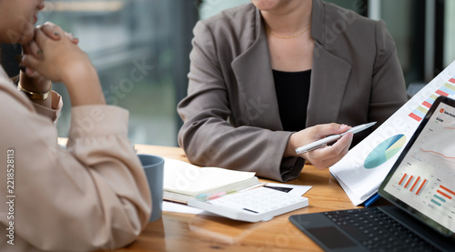 Businesswoman Holding Pen Explaining Financial Charts to Client in Meeting