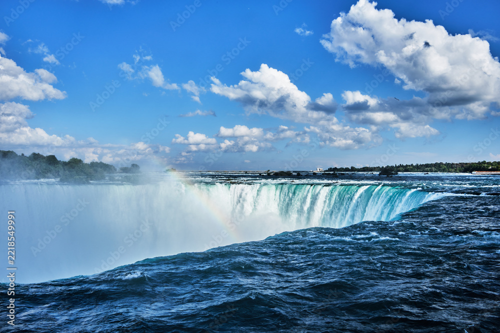 Fototapeta premium Looking across the brink of Horseshoe Falls, Niagara, Canada, with rainbow
