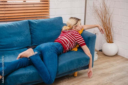 Exhausted woman sprawled on sofa after long tiring day at home