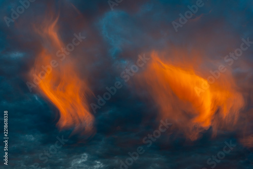 Stimmungsvoller Abend-oder Morgenhimmel mit blauem Hintergrund und von der tiefstehenden Sonnen orange angestrahlten Cirruswolken