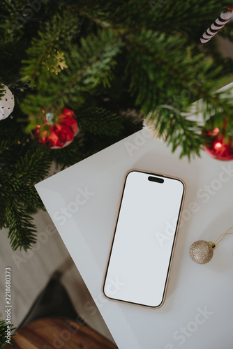 Top View Smartphone Mockup On White Table Near Decorated Christmas Tree