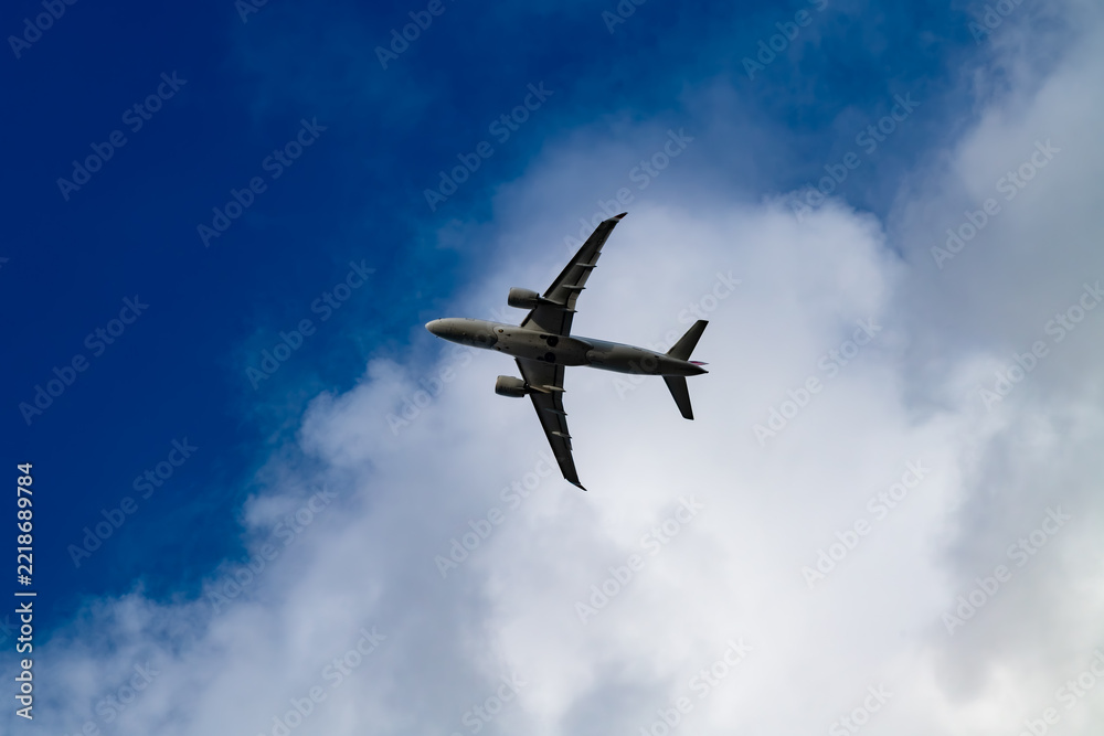 Fototapeta premium Commercial passenger aircraft seen from below while approaching or departing Sylt Airport near Westerland on the North Sea island of Sylt, Germany.