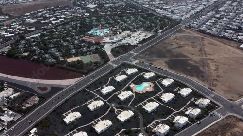 Aerial view of a residential area with roads houses and a large empty lot