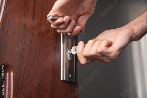 Male hands opening or closing door at home.