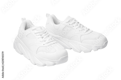 Fotografie White sneakers with a chunky sole on a plain background in a bright setting