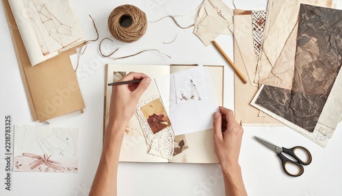 Hands Creating Scrapbook with Photos and Paper Collage