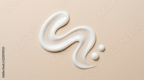 Sshaped smear of white cosmetic cream with two small droplets on a beige background