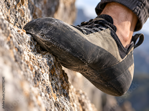 Climbing shoe gripping a rough rock foothold in close up