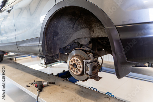 Pneumatic impact wrench on a lift platform with air hose, close-up of tire change tools in an auto repair garage