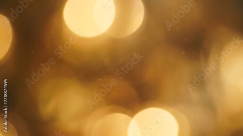Abstract golden light bokeh background with glowing circles and soft blurred flares