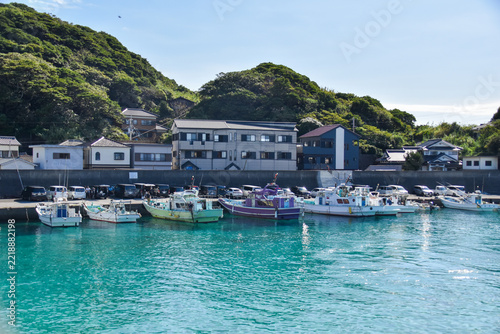 エメラルドグリーンの透き通る海に幾重もの船が繋がれた柏島の港風景