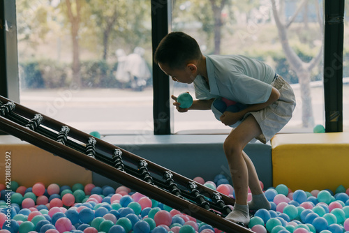 An Asian girl is climbing and playing at the amusement park; Asian families are traveling and relaxing
