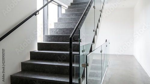 Modern Staircase with Glass Railings and Black Handrail.