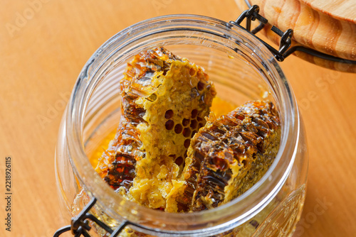 Fresh honeycomb pieces with honey inside glass jar