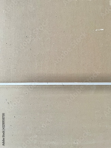 Close up view of brown corrugated cardboard surface texture with a white line across the center for background design