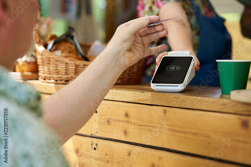 Close Up Of Person Making Contactless Payment For Takeaway Coffee