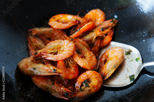 Fresh shrimp cooking in a wok with metal spatula