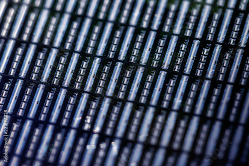 Macro detail of microchip grid on silicon wafer closeup background highlighting circuits and rows for technical