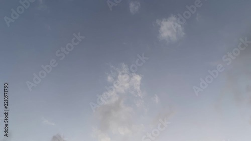 Moody cloudscape time lapse with dark grey clouds drifting fast through a blue sky. Dramatic atmospheric background for weather changes, approaching storm, meteorology concepts or sky replacement.