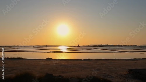 Golden sunset over tranquil salt pans near Trapani, Italy
