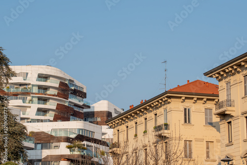 A striking urban landscape showcases the juxtaposition of historic architecture and avant-garde contemporary design against a clear, serene sky