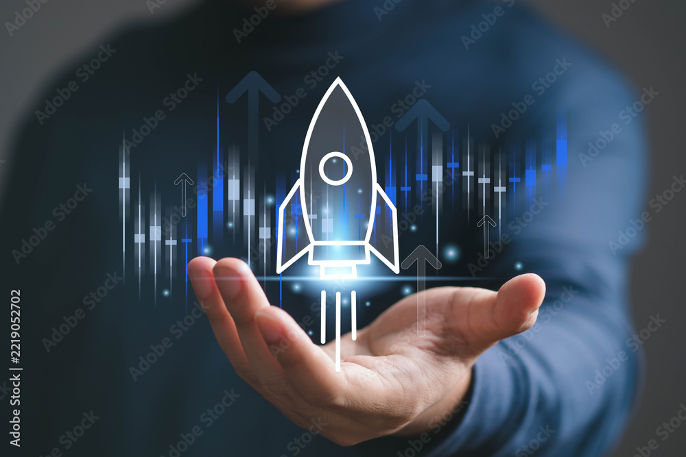 Fototapeta premium Digital startup growth concept showing a glowing rocket launching above a business skyline from an open hand, symbolizing innovation, entrepreneurship, technology, investment, progress, future success