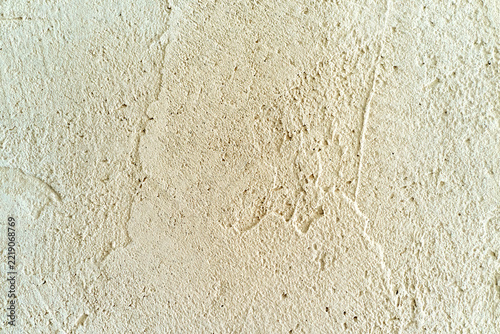 Fotografie Close-up beige plaster wall texture with visible cracks, hairline lines, and rou