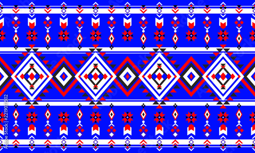 Geometric tribal pattern featuring traditional ethnic and bohemian motifs with diamond shapes in vibrant blue, red, white, and black tones.