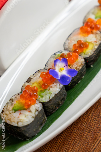 Close-up of sushi rolls topped with orange fish roe