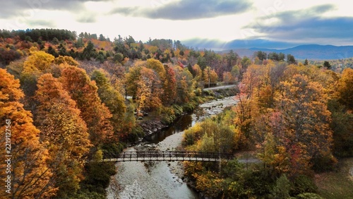 Bridge and bike path river scene during peak fall colors in Vermont