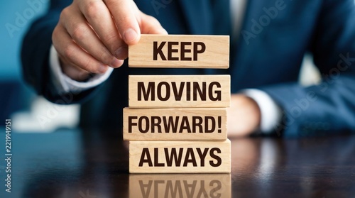 Motivational concept with wooden blocks spelling keep moving forward always