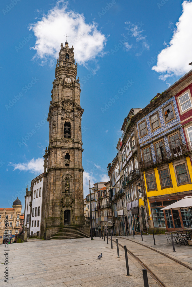 Obraz premium Famous Clerigos Tower rising above historic buildings in Porto city center, showcasing baroque architecture and urban landscape in northern Portugal.