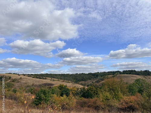 Scenic Countryside Landscape of Rolling Green Hills under Blue Sky
