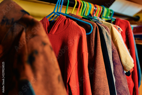Clothes Hanging on Colorful Plastic Hangers on a Rack