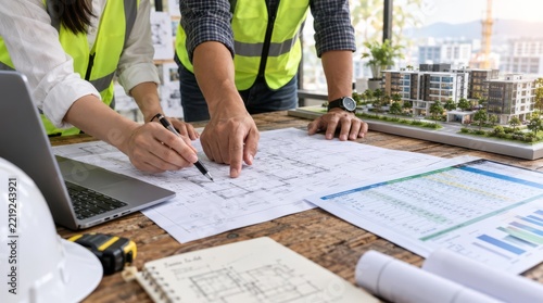 Architects discussing building blueprints and architectural model planning