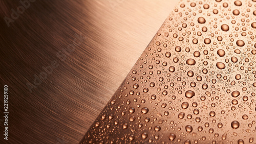 Rain beads on brushed copper with dark copy space