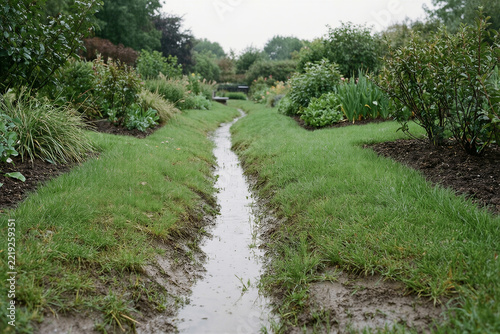 Swale carrying rainwater through a planted public garden