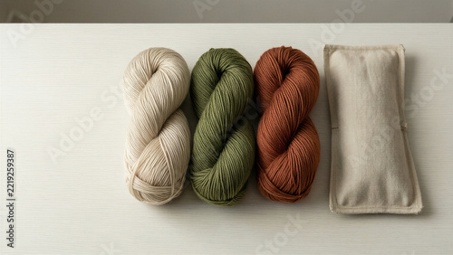 Natural yarn skeins beside an empty knitting needle case