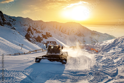 Snow groomers preparing ski slopes at Shymbulak Mountain Resort in Almaty, Kazakhstan, during winter season