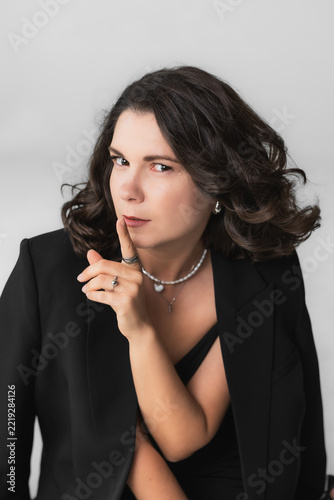 Obraz na plátně Intriguing forty year old woman showing hush silence gesture with finger on lips