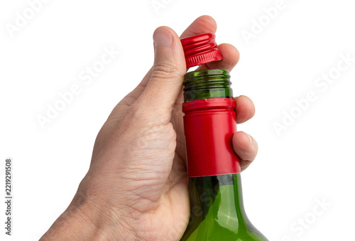 Hand Opening Green Wine Bottle With Red Screw Cap Isolated On White Background