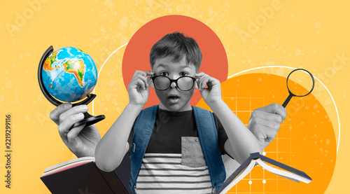 Surprised Young Boy, Caucasian, Wearing Glasses, Studying Globe And Books At School, Engaged In Learning, Exploring Knowledge. Education Concept Focused On Academic Growth And Curiosity.
