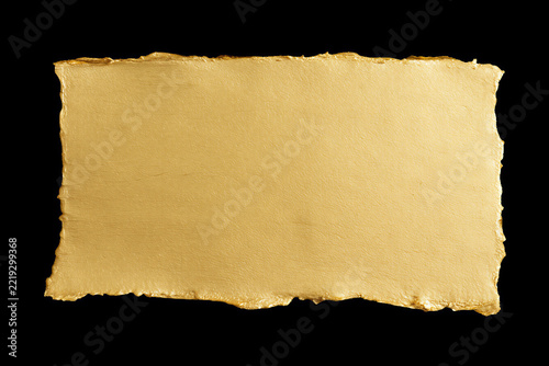 Gold textured paper sheet with torn edges isolated on black background