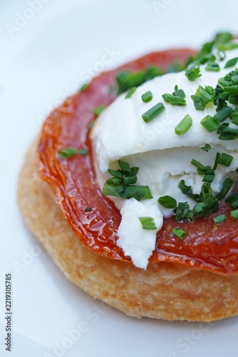 View of a tomato tarte Tatin upside down pie with cheese and chives