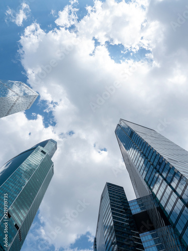 Modern glass skyscrapers with reflective facades rising against a clear blue sky in an urban setting