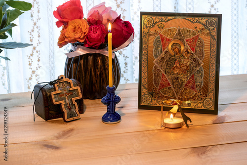 Fotografie Orthodox Christian icon of the Virgin Mary and child with candles and cross on a wooden table